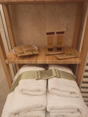 列蒂L'Angelo pellegrino miniappartamenti的浴室里备有毛巾和两杯的书架