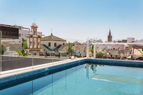 塞维利亚Radisson Collection Hotel, Magdalena Plaza Sevilla的建筑物屋顶上的游泳池