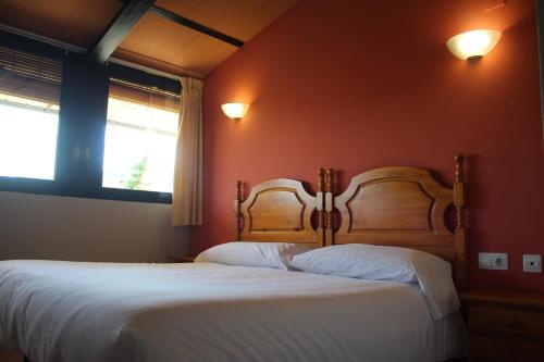赫里卡Hotel De Jerica的卧室设有两张床铺、红色墙壁和两扇窗户