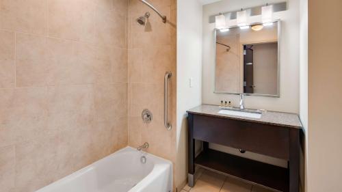 克拉克斯维尔卡兴贝斯特韦斯特PLUS酒店的带浴缸、水槽和镜子的浴室