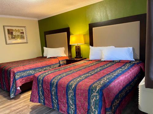加洛韦经济汽车旅馆的绿墙旅馆客房的两张床
