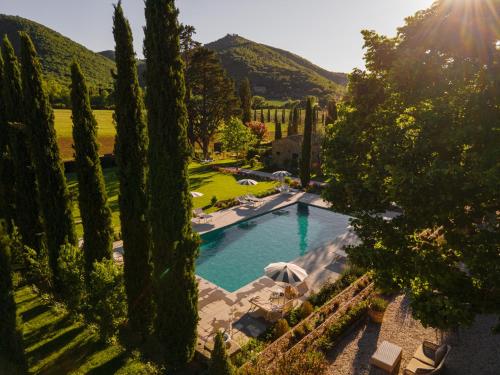 科尔托纳Villa di Piazzano - Small Luxury Hotels of the World的花园内树木繁茂,享有游泳池的顶部景致