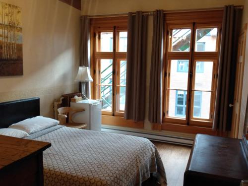 魁北克市L管理酒店的一间卧室设有一张床和一个大窗户
