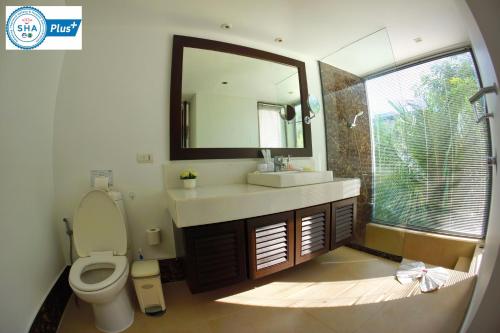 邦涛海滩Casuarina Shores Apartment - SHA Plus的一间带卫生间、水槽和镜子的浴室