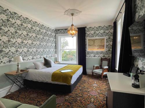 奥玛鲁Casa Nova House的卧室配有床、椅子和窗户。