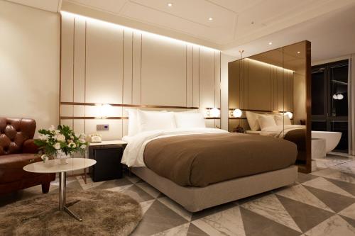 首尔9布里克酒店的一间卧室配有一张床、一张沙发和一张桌子