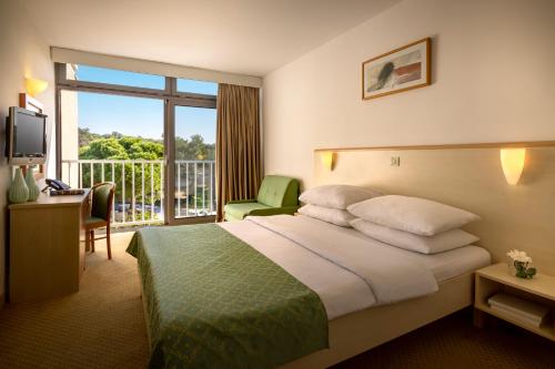 波雷奇Rubin Sunny Hotel的酒店客房设有一张床和一个阳台。