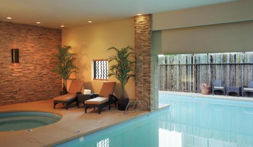 阿尔伯克基Nativo Lodge的一个带椅子的游泳池和一个游泳池