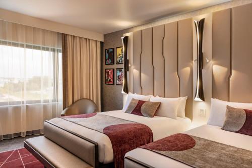 谢西Disney Hotel New York - The Art of Marvel的酒店客房设有两张床和窗户。