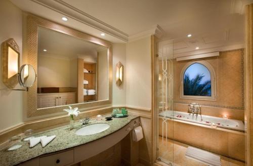 赫尔格达索马湾凯宾斯基酒店的一间带水槽、浴缸和镜子的浴室