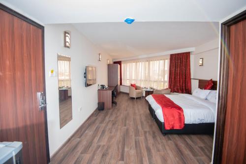 内罗毕The Crossroads Hotel, Westlands的配有一张床和一张书桌的酒店客房