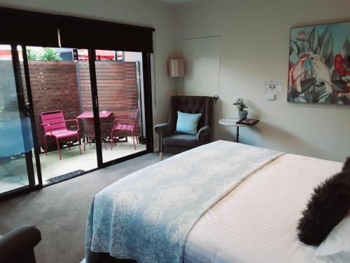 伊丘卡Adelphi Apartment 2- Poolside or Apartment 2A- King Studio的卧室配有一张床和一张桌子及椅子