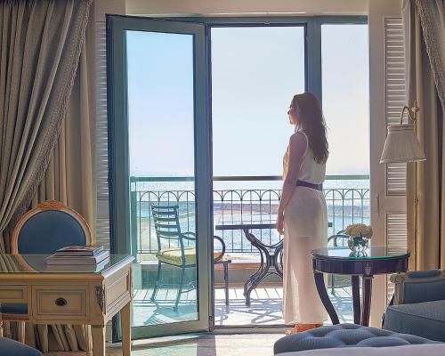 亚历山大亚历山大港圣斯特凡诺四季酒店的站在一个眺望海洋的房间的女人