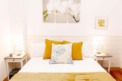 毕尔巴鄂Dolaretxe apartment by People Rentals的一间卧室配有白色床和黄色枕头