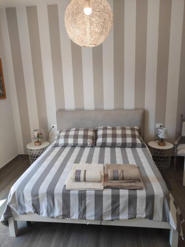 佩萨罗Rossetto e cocciolato - Stanza indipendente con bagno privato a Pesaro的一间卧室配有一张带条纹墙壁的床和吊灯。