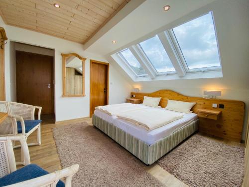 瓦尔德克Landhotel Edersee的一间卧室设有一张大床和天窗