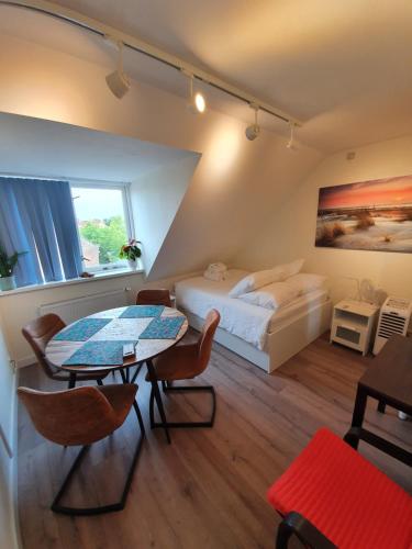 海牙Scheveningen Sea Side的卧室配有一张床和一张桌子及椅子
