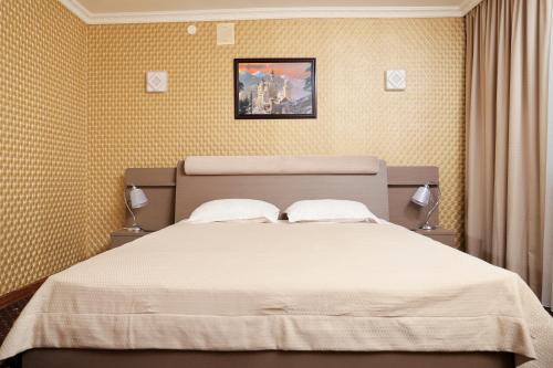 尼古拉耶夫Green City Hotel的一间卧室配有一张带白色床单的大床