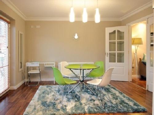 邓甘嫩Luxurious KC House的一间带桌子和绿色椅子的用餐室