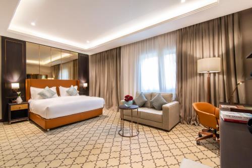 利雅德Gardino Hotel & Residence的大型酒店客房,配有床和沙发