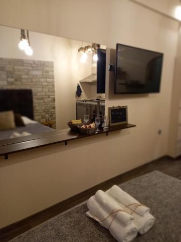 雅典Lux Studio 1的客厅配有电视,地板上备有毛巾。