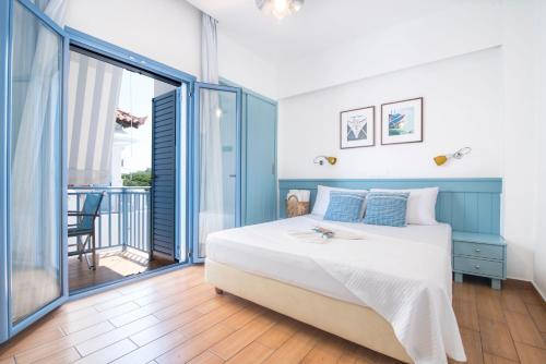 斯卡拉Saronis Hotel Agistri - Adults Only的一间带大床的卧室和一个阳台