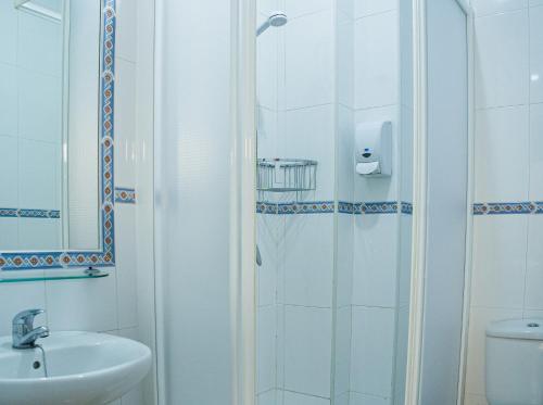 蓬塔翁布里亚Hostal Patio Andaluz的带淋浴、盥洗盆和卫生间的浴室