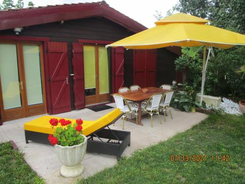 艾特雷Locatlantique的天井配有桌子和黄色雨伞