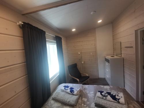基蒂莱Maglelin Experience Lodge的客房设有床、椅子和窗户。