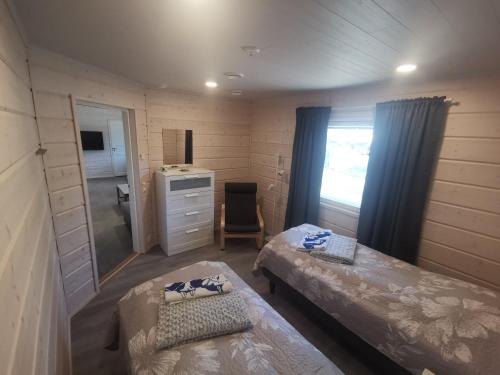 基蒂莱Maglelin Experience Lodge的小房间设有两张床和镜子