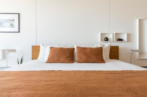 蒙得维的亚Opta Coliving Punta Carretas的一间卧室配有带白色床单和棕色枕头的床。