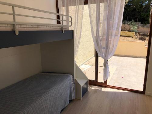 杰若米斯Casa Daniela - Kala & Moru的一间卧室设有一张双层床和大窗户。
