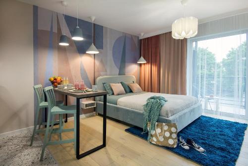 科沙林W&K Apartments - Joy Suite的一间卧室配有一张床铺和一张桌子,还有一间用餐室