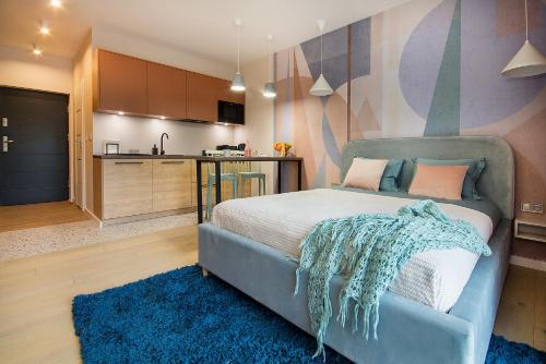 科沙林W&K Apartments - Joy Suite的一间带蓝色床的卧室和一间厨房