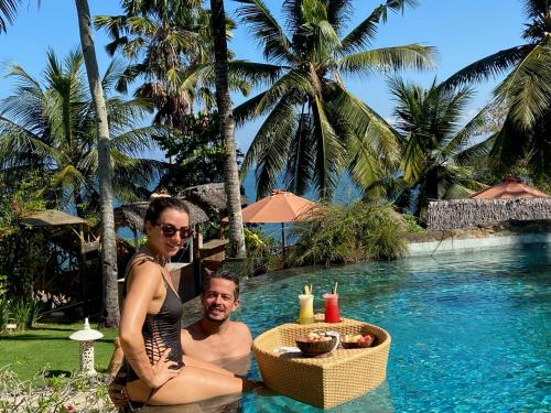 普卢坎普里达桔马海滩生态度假酒店的坐在游泳池里的男人和女人