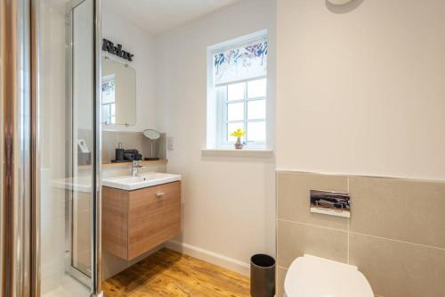 因弗内斯Stylish & Modern Apartment的一间带卫生间、水槽和窗户的浴室
