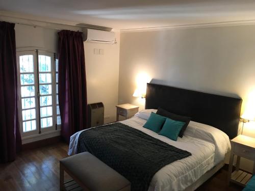 卢汉德库约Chenin Lodge的一间卧室配有一张大床和两个蓝色枕头