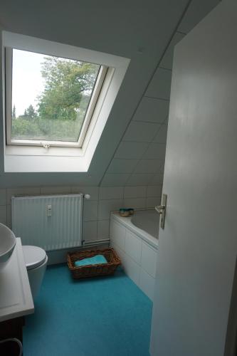 吕讷堡Mirabella的浴室设有窗户、卫生间和浴缸。