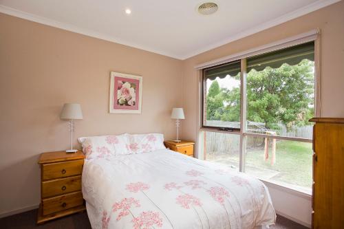吉朗吉朗度假屋酒店的一间卧室设有一张床和一个大窗户