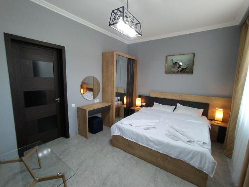 第比利斯Nice Apartments Tbilisi的卧室配有一张白色大床和镜子