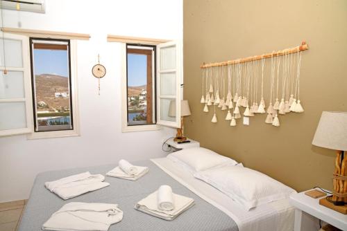 卢特拉NEFELI SUITES KYTHNOS的客房设有2张床、白色毛巾和窗户。