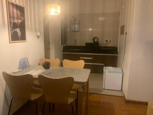 罗纳瓦拉Mizzle Exotica Lonavala的一间带桌椅的厨房和一间带冰箱的厨房