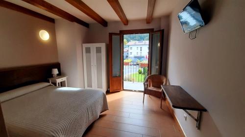 莱特萨Hostal Lopenea的一间卧室配有一张床、一张桌子和一个窗户。