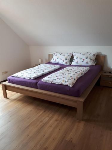魏斯基兴Haus Rosi的卧室内的一张带紫色床单和枕头的床