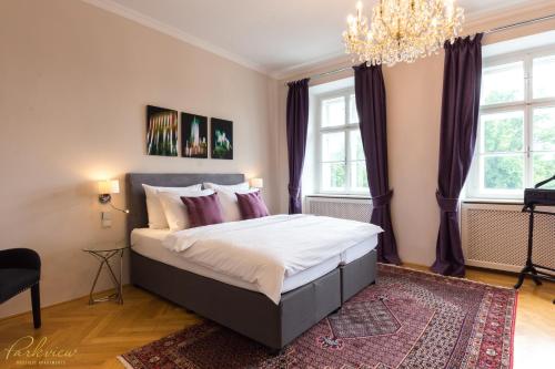 维也纳Parkview Boutique Apartments的一间卧室配有一张带紫色窗帘和吊灯的床。