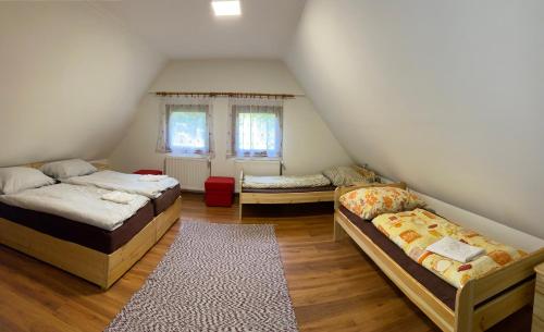 KarancsaljaTavas Vendégház的阁楼间 - 带3张床和地毯