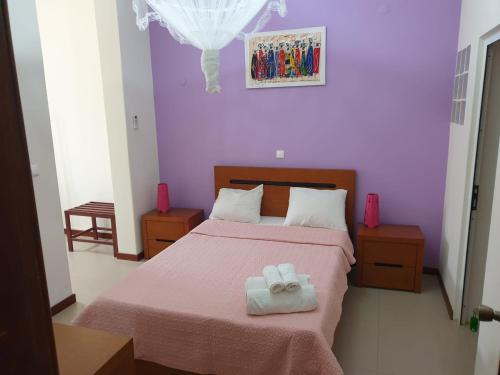 Cidade VelhaCactus Guest House的一间卧室配有一张床,上面有两条毛巾