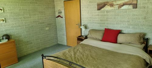 索斯特克拉维吉住宿加早餐旅馆的一间卧室配有一张红色枕头的床