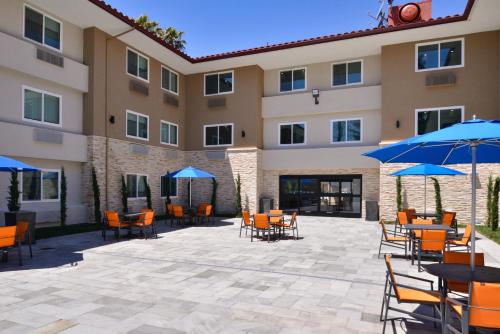 圣罗莎Holiday Inn Express - Santa Rosa North, an IHG Hotel的酒店前方设有带桌子和遮阳伞的庭院。