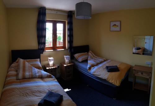 布里奇沃特Walnut Lodge, Summerhayes的一间卧室设有两张床和窗户。